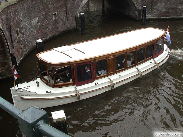 photo de bateau vitré dans les canaux passe sous un pont