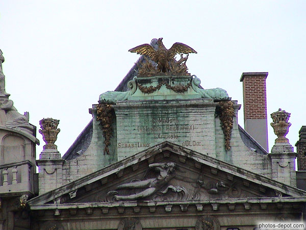 photo de sphinx surmontant la maison des archers, inscription : brulée, je ressusciterai plus glorieuse par les soins de la gilde de st Sébastien