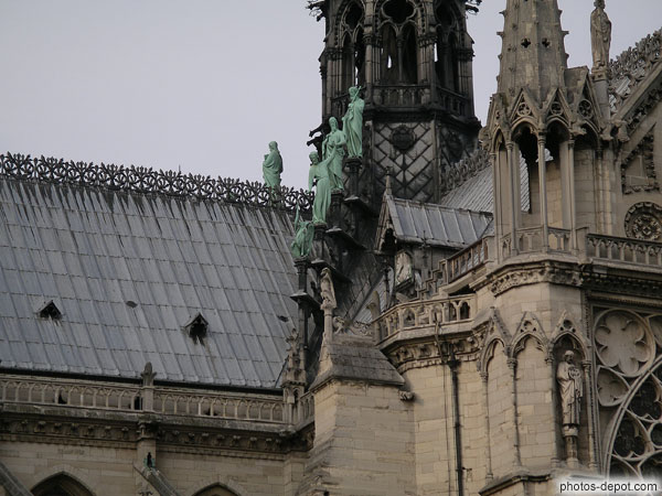 photo de statues semblent descendre le long du toit de la cathédrale Notre Dame