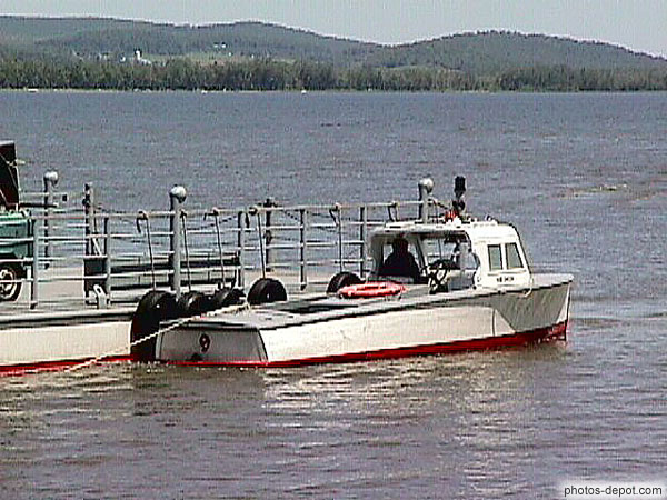 photo de petit bateau tractant le traversier du lac d'Oka