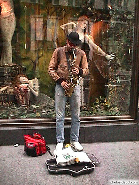 photo de joueur de saxophone devant vitrine