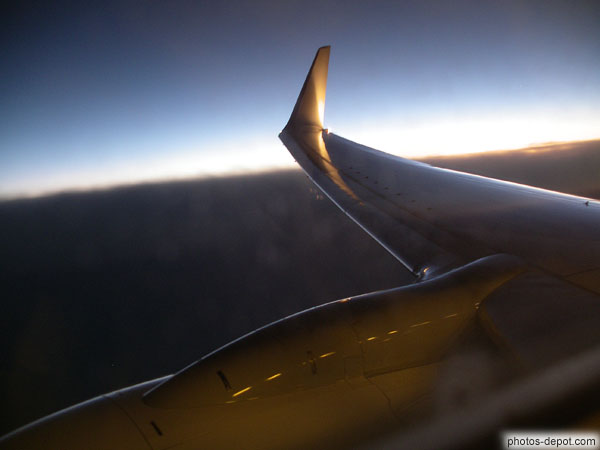 photo d'aile d'avion en vol, à l'aurore