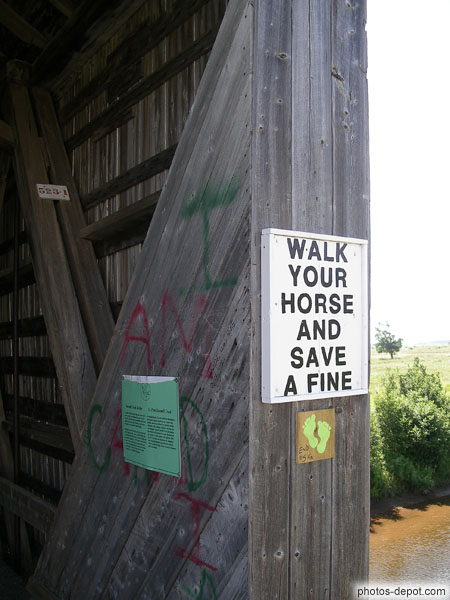 photo de Walk your horse and save a fine affiché à l'entrée du pont de bois