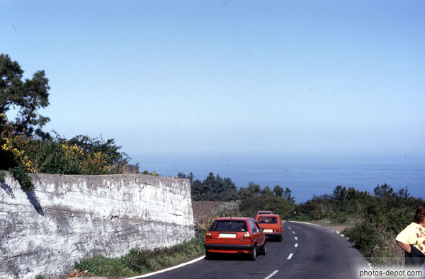 photo de voitures rouges sur la route descendant vers la mer