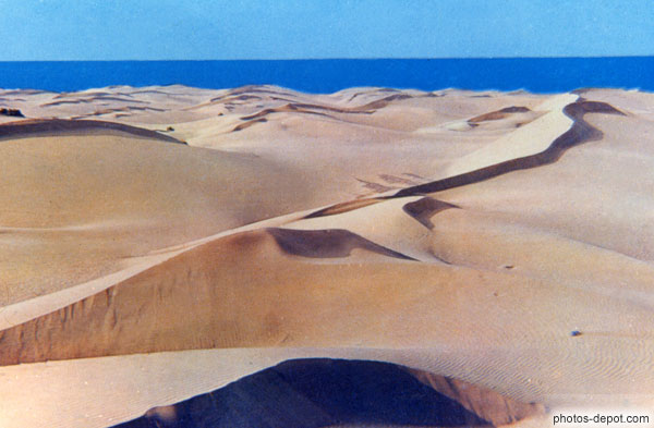 photo de dunes de sable devant la mer