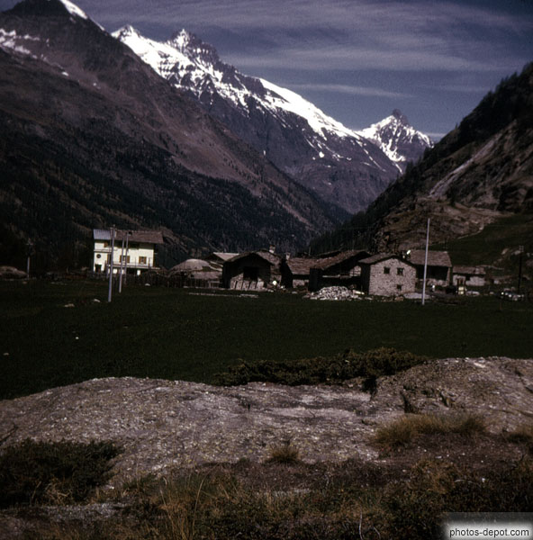 photo de village sur le plateau et pics enneigés