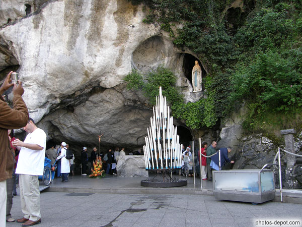 photo de cierges déposés en attente d'être allumés devant la grotte des apparitions