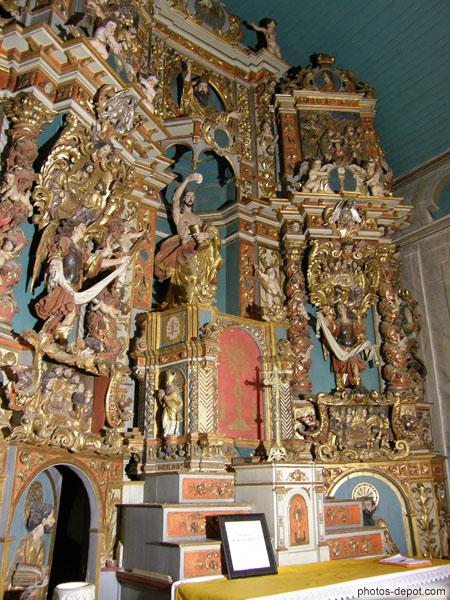 photo de retable baroque de bois doré ou trône un Christ brandissant l'Hostie