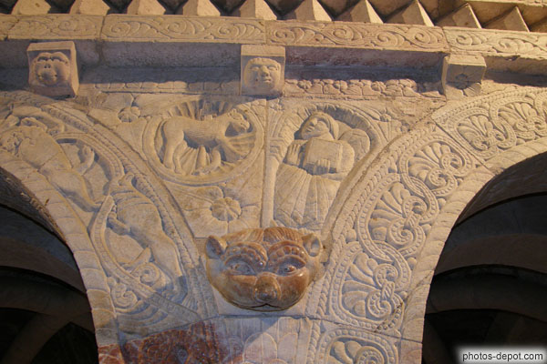 photo d'au centre de la facade ciselée en faible relief :  homme ailé de St Mathieu et Christ représenté par un agneau dans une mandorle
