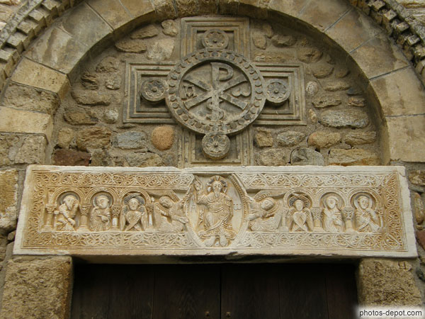 photo de linteau de marbre, présentant la même structure que celui de Saint-Génis. tympan décoré d?une croix de Saint André, portant le chrisme en son centre, frise en dents d'engrenage et en arcs plein cintre