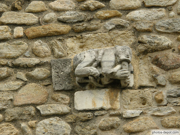 photo d'Une des 2 sculptures de créatures monstrueuses ornant la facade de l'église : Simiot semblant manger un serpent