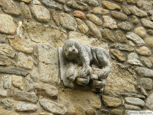 photo d'Une des 2 sculptures de créatures monstrueuses ornant la facade de l'église : Simiot tenant un agneau