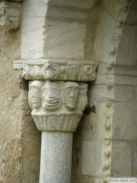 photo de Chapiteau orné de visages sculptés, au dessus, un Christ en pleurs, portail de marbre