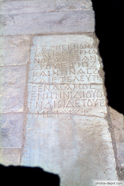 photo de pierre aux inscriptions grecques, croix et chadelier à 7 branches