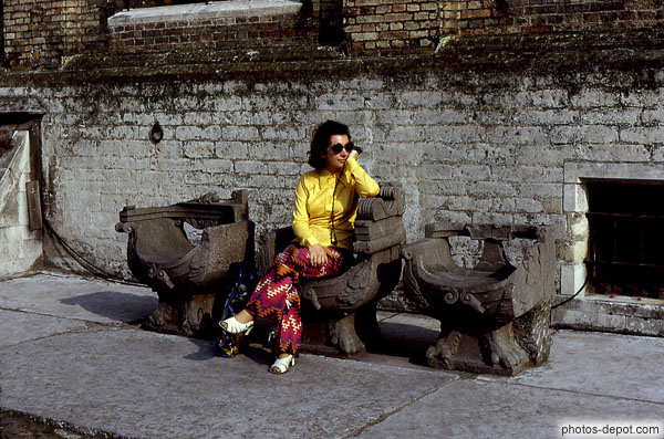 photo de femme assise sur un des 3 fauteuils de pierre
