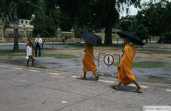 photo de moines en robe orange et parapluie