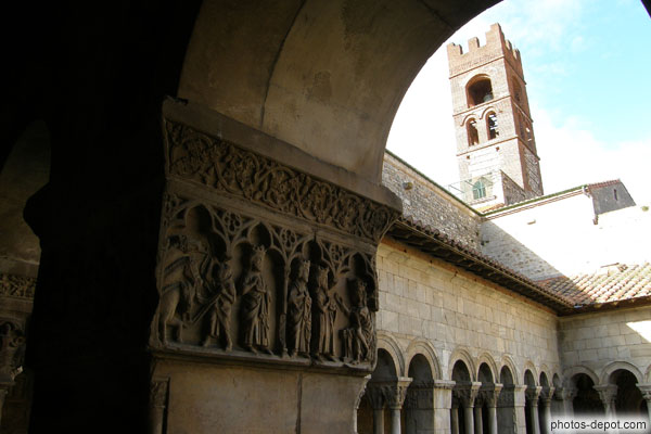 photo de scène des rois mages chez Hérode sur chapiteau du cloître, et tour fortifiée de l'Abbaye