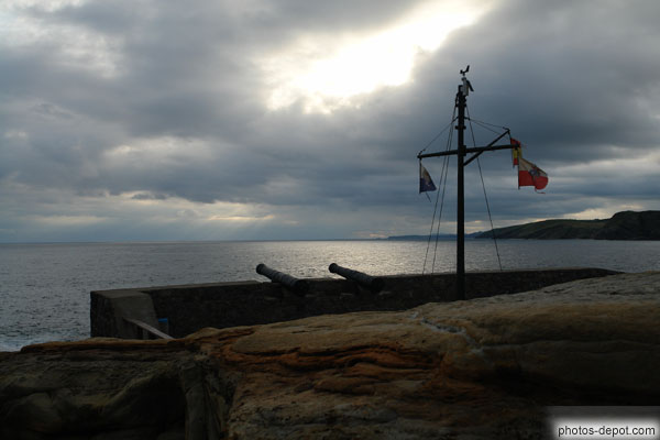 photo de mat aux drapeaux et canons sur le port