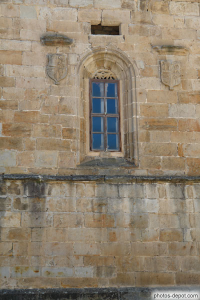 photo de fine fenêtre surmontée d'une arche plein cintre et de deux blasons