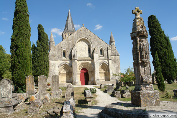 photo de croix hosannière gothique du XVe s. précède la facade principale. St Pierre, St Paul, St Jean et St Jacques en accolade