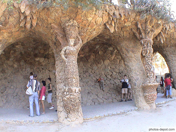 photo de colonnes-piliers en pierres non dégrossies bordant une avenue couverte de Gaudi