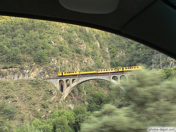 photo de petit train jaune sur viaduc