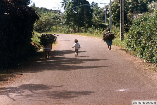 photo de femmes et enfant portant du bois sur la route