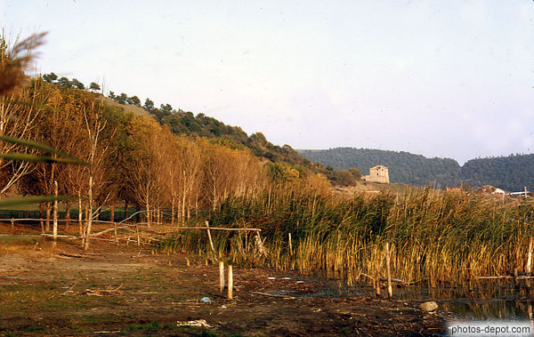 photo de rive du lac de martignano et batisse au loin