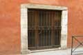 Porte fenêtre à grille, linteau de bois et mur rouge / France, Languedoc Roussillon, Perpignan