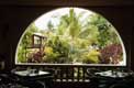 Tables de restaurant face au jardin luxuriant aux singes