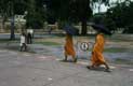 Moines en robe orange et parapluie / Thailande